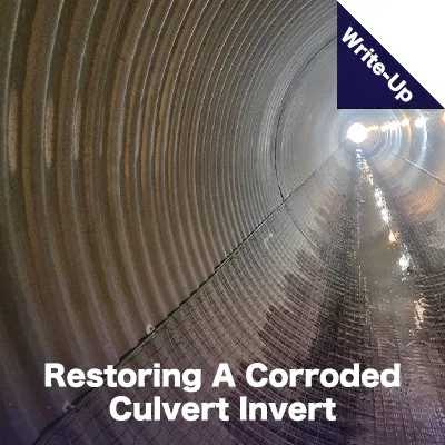 A long corrugated metal pipe with wire mesh along the invert in preparation for field paving