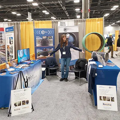 Jennifer standing in HydraTech's booth at the OTEC tradeshow