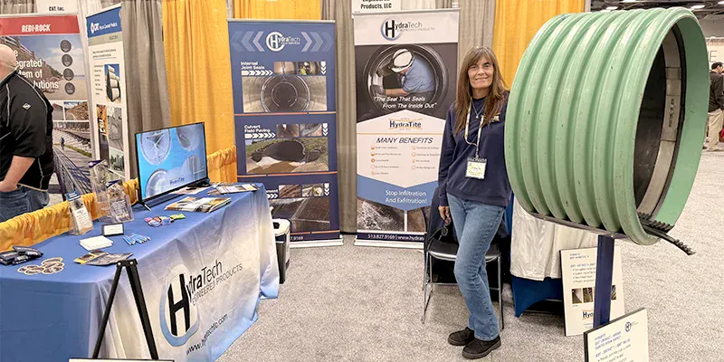 Jennifer standing in HydraTech's booth at OTEC