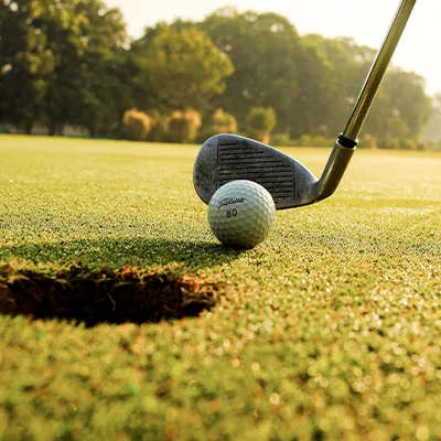 Preparing to tap a golf ball into a hole