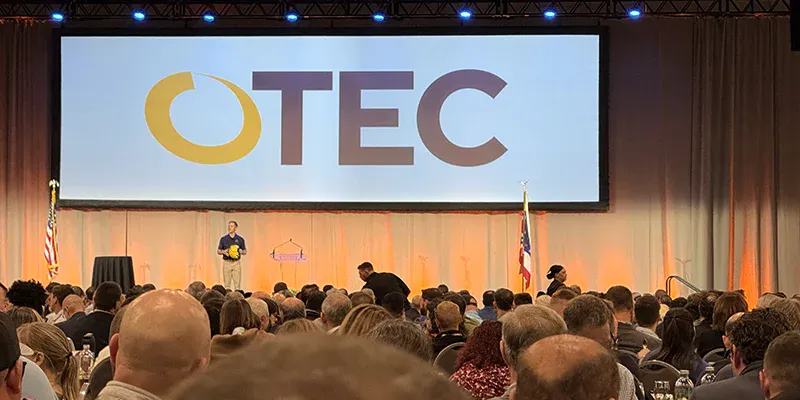 A man talking on a stage at OTEC