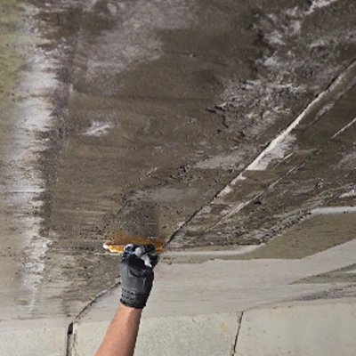 A gloved hand applying epoxy to the under side of a bridge