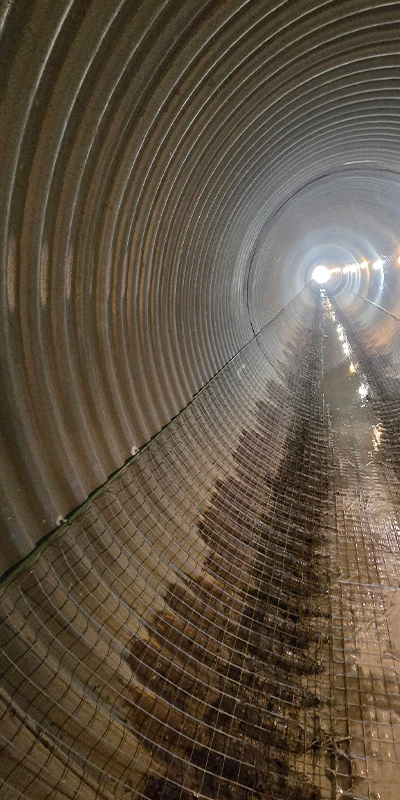 wire mesh laying over the inver of a long culvert