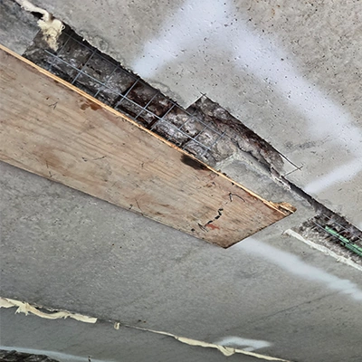A piece of wood holding concrete patchwork in place