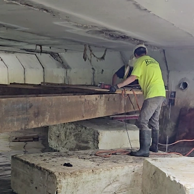 Technicians preparing to work on the underside of a bridge